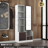 A white and brown Maven Dressing Table with a mirror, model BFT217, displayed in a room with various clothes and accessories arranged around it.